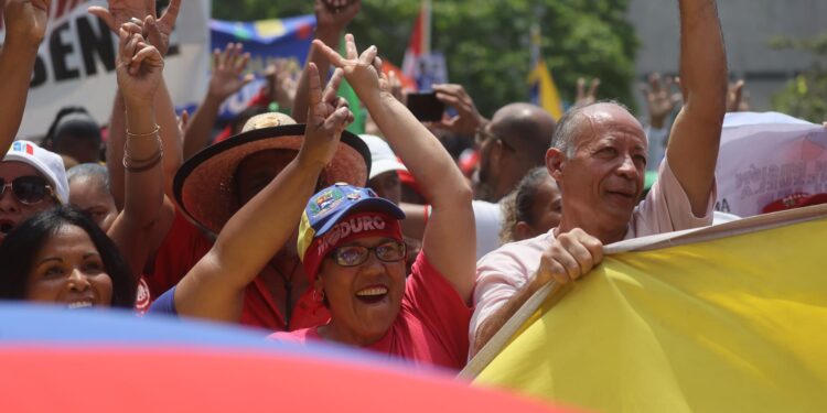 AME2269. CARACAS (VENEZUELA), 25/03/2024.- Simpatizantes del oficialismo se reúnen este lunes para mostrar su apoyo y acompañar a su candidato a las próximas elecciones del 28 de julio, el actual mandatario Nicolás Maduro, a oficializar su aspiración ante el Consejo Nacional Electoral (CNE), en Caracas (Venezuela). El proceso de presentación de candidaturas para las presidenciales concluye este lunes, con la inscripción de Maduro, mientras que la oposición mayoritaria espera poder postular a Corina Yoris, su aspirante ante la inhabilitación de María Corina Machado, ganadora de las primarias de octubre. EFE/ Miguel Gutiérrez