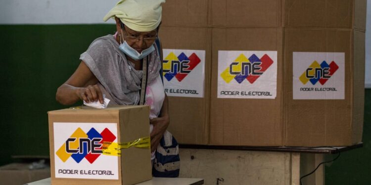 A woman casts her vote at the Jose de Jesus Arocha public school in Petare, Caracas, during a mock election for the upcoming parliamentary vote in Venezuela, on November 15, 2020, amid the COVID-19 novel coronavirus pandemic. - Venezuela holds parliamentary elections on December 6 with President Nicolas Maduro looking to take back control of the National Assembly, whose speaker and opposition leader Juan Guaido is demanding a boycott. (Photo by Cristian HERNANDEZ / AFP)