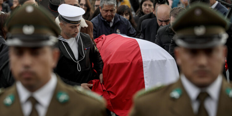 AME1673. LEBU (CHILE), 30/04/2024.- Policías y militares acompañan el féretro de su compañero el suboficial mayor Sergio Antonio Arévalo, uno de los tres agentes de Carabineros asesinados este fin de semana en la zona centro-sur de Chile, durante su entierro este martes en el cementerio municipal de Lebu, en la región de Bio Bío (Chile). Los tres agentes fueron enterrados este martes en medio aún de la conmoción que ha generado en el país este triple atentado, el más grave que se recuerda contra el cuerpo policial y por el que aún no hay ningún detenido. Familiares, amigos y vecinos acudieron a despedir los restos de los tres agentes en las ceremonias casi simultáneas que se celebraron por separado en sus respectivas localidades Lebu, Los Álamos y Curanilahue, 600 kilómetros al sur de la capital, profundamente remecidas por lo ocurrido. EFE/ Ignacio Vásquez