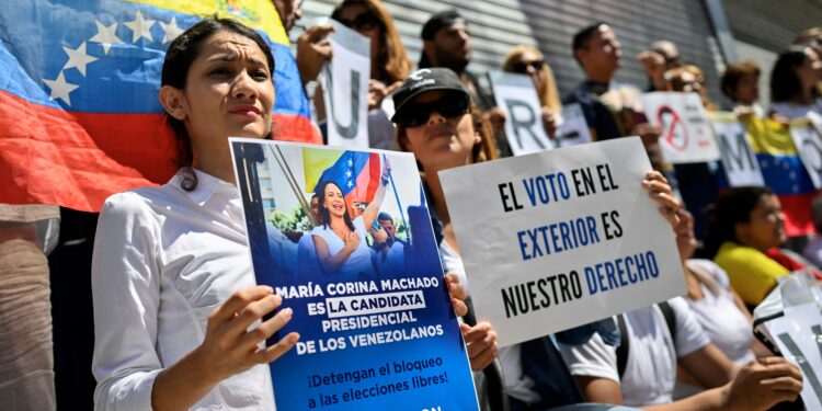 Venezuelans in Argentina protest outside the Venezuelan embassy in Buenos Aires on March 25, 2024, calling for the electoral registry to be enabled so they could vote in the upcoming July 28 presidential elections in Venezuela. - Venezuelans go to the polls on July 28 after a grim decade marked by an economic crisis that has pushed millions to flee the country. (Photo by Luis ROBAYO / AFP)