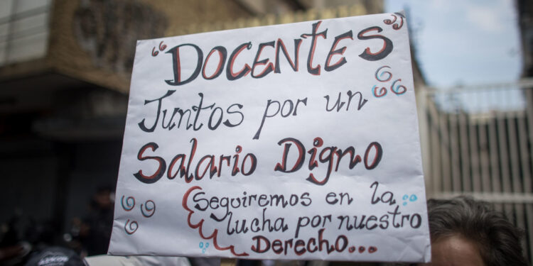 AME1938. CARACAS (VENEZUELA), 01/05/2024.- Fotografía de un letrero durante una manifestación en conmemoración del Día Internacional de los Trabajadores este miércoles, en Caracas (Venezuela). Sindicatos y trabajadores de Venezuela salen a las calles a protestar para exigir un incremento de sus salarios y mejoras en los beneficios laborales. EFE/ Miguel Gutiérrez