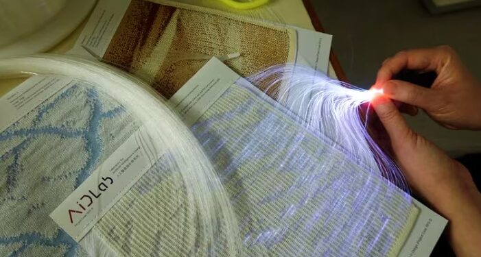 Imagen de unos investigadores revisando la transparencia de textiles inteligentes integrados con fibra óptica en Hong Kong, China, 2023. (REUTERS/Joyce Zhou)