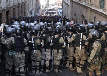 AME6897. LA PAZ (BOLIVIA), 26/06/2024.- Integrantes de la Policía Militar se forman frente a simpatizantes del presidente Luis Arce durante una protesta contra los militares que tomaron la sede del Gobierno de Bolivia, este miércoles en La Paz (Bolivia). Este miércoles un grupo de militares encabezados por el que hasta hoy era el Comandante General del Ejército de Bolivia, Juan José Zuñiga, tomó la plaza y con un tanque tiró la puerta de la sede del Gobierno del presidente Luis Arce quien calificó la acción como un "intento de golpe de Estado". EFE/ Luis Gandarillas