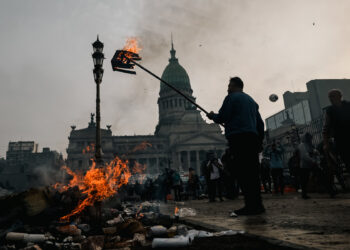 AME3498. BUENOS AIRES (ARGENTINA), 12/06/2024.- Un hombre quema una caja durante enfrentamientos entre la policía y personas que protestan a las afueras del senado durante un debate este miércoles, en Buenos Aires (Argentina). Manifestantes y policías protagonizan un choque este miércoles a las puertas del Senado de Argentina mientras la cámara legislativa debate la ley de Bases, el proyecto estrella del Gobierno, con el que el presidente Javier Milei pretende implementar un paquete de reformas económicas de gran calado. EFE/ Juan Ignacio Roncoroni