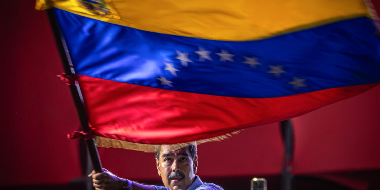 AME4896. CARACAS (VENEZUELA), 25/07/2024.- El presidente de Venezuela y aspirante a la reelección, Nicolás Maduro, agita una bandera en el cierre de su campaña este jueves, en Caracas (Venezuela). Maduro aseguró que cuenta con una "nueva mayoría" que lo respaldará en los comicios de este domingo, en los que buscará una segunda reelección, para lo que deberá enfrentarse contra nueve contendientes. EFE/ Henry Chirinos