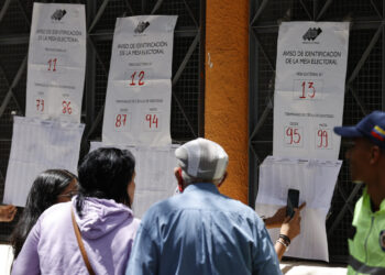 AME5617. CARACAS (VENEZUELA), 28/07/2024.- Ciudadanos venezolanos buscan su mesa de votación durante la jornada de elecciones presidenciales de Venezuela este domingo, en Caracas (Venezuela). El CNE informó este domingo que, sobre las 08.00 hora local (12.00 GMT), el 95 % de los 15.797 centros de votación ya estaban abiertos -dos horas más tarde la hora oficial fijada para la apertura- y computando los votos de personas que acudieron desde muy temprano a las urnas. EFE/ Henry Chirinos