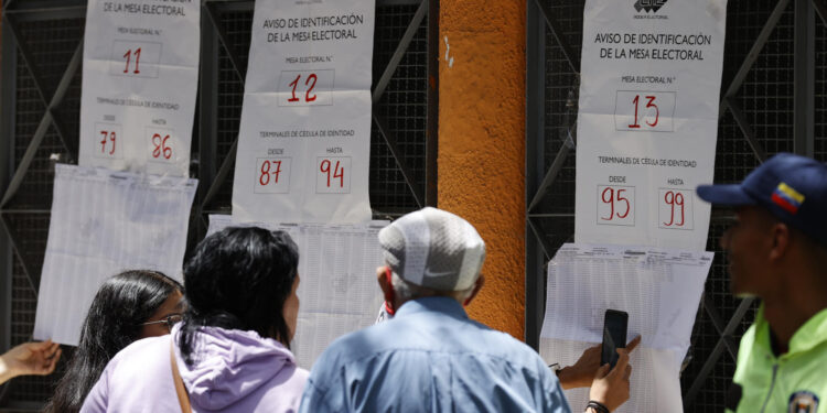 AME5617. CARACAS (VENEZUELA), 28/07/2024.- Ciudadanos venezolanos buscan su mesa de votación durante la jornada de elecciones presidenciales de Venezuela este domingo, en Caracas (Venezuela). El CNE informó este domingo que, sobre las 08.00 hora local (12.00 GMT), el 95 % de los 15.797 centros de votación ya estaban abiertos -dos horas más tarde la hora oficial fijada para la apertura- y computando los votos de personas que acudieron desde muy temprano a las urnas. EFE/ Henry Chirinos