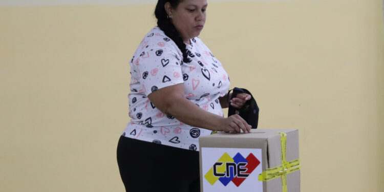 AME5564. CARACAS (VENEZUELA), 28/07/2024.- Una mujer vota este domingo, en un centro de votación en Caracas (Venezuela). Venezuela elegirá presidente en una jornada para la que están llamadas a las urnas más de 21 millones de personas. El Consejo Nacional Electoral (CNE) de Venezuela informó este domingo que, sobre las 08.00 hora local (12.00 GMT), el 95 % de los 15.797 centros de votación ya estaban abiertos -dos horas más tarde la hora oficial fijada para la apertura- y computando los votos de personas que acudieron desde muy temprano a las urnas. EFE/ Ronald Peña R.