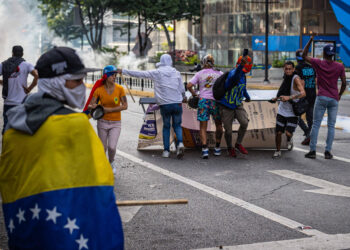 AME6327. CARACAS (VENEZUELA), 29/07/2024.- Manifestantes se enfrentan a la Guardia Nacional Bolivariana (GNB), por los resultados de las elecciones presidenciales este lunes, en Caracas (Venezuela). Este lunes, miles de ciudadanos han salido para protestar contra los resultados anunciados por el Consejo Nacional Electoral (CNE), que otorga al presidente Maduro el 51,2 % de los votos, un dato cuestionado por la oposición y por buena parte de la comunidad internacional. EFE/ Henry Chirinos