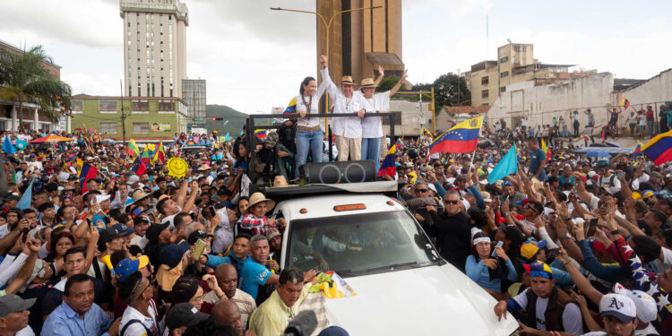 AME1670. VALENCIA (VENEZUELA), 13/07/2024.- La lider de la oposición, María Corina Machado (i) junto a el candidato presidencial, Edmundo González (c) participan en un acto de campaña este sábado en la ciudad de Valencia, estado de Carabobo (Venezuela). La líder opositora de Venezuela María Corina Machado sorteó este sábado "obstáculos" en su viaje hacia Valencia, estado Carabobo, al superar dos cierres de la autopista que conduce hacia esa ciudad, donde encabezará un acto de campaña junto al candidato presidencial Edmundo González Urrutia, de cara a las elecciones del 28 de julio. EFE/ Ronald Peña