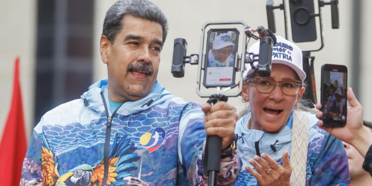 AME9271. CARACAS (VENEZUELA), 04/07/2024.- El presidente de Venezuela Nicolás Maduro (c) y su esposa Cilia Flores saludan a sus seguidores este jueves, en Caracas (Venezuela). El presidente de Venezuela, Nicolás Maduro, habló este jueves, en su primer acto de campaña para las elecciones del 28 de julio, de una "profecía" de pastores cristianos, según la cual el país ha entrado en un período de siete años de prosperidad, que acompañarán a quien gane los comicios. EFE/ Miguel Gutiérrez