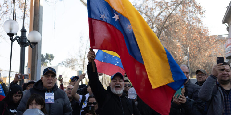 AME5557. SANTIAGO (CHILE), 28/07/2024.- Un ciudadano venezolanos agita una bandera a su llegada a votar en las elecciones presidenciales de Venezuela este domingo, al consulado de Venezuela en Santiago (Chile). EFE/ Ailen Díaz