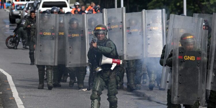 Members of the Bolivarian National Guard clash with opponents of Venezuelan President Nicolas Maduro's government during a protest at the El Valle neighborhood in Caracas on July 29, 2024, a day after the Venezuelan presidential election. - Protests erupted in parts of Caracas Monday against the re-election victory claimed by Venezuelan President Nicolas Maduro but disputed by the opposition and questioned internationally, AFP journalists observed. (Photo by Federico PARRA / AFP)