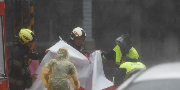 Hualien (Taiwan), 31/10/2024.- Firefighters and police remove a large banner, as Typhoon Kong-Rey made landfall in Hualien, Taiwan, 31 October 2024. Super typhoon Kong-Rey, bringing catastrophic winds and heavy rains, has forced schools, businesses, and transportation across the island to suspend or temporarily shut as it makes landfall in the eastern part of Taiwan. EFE/EPA/DANIEL CENG