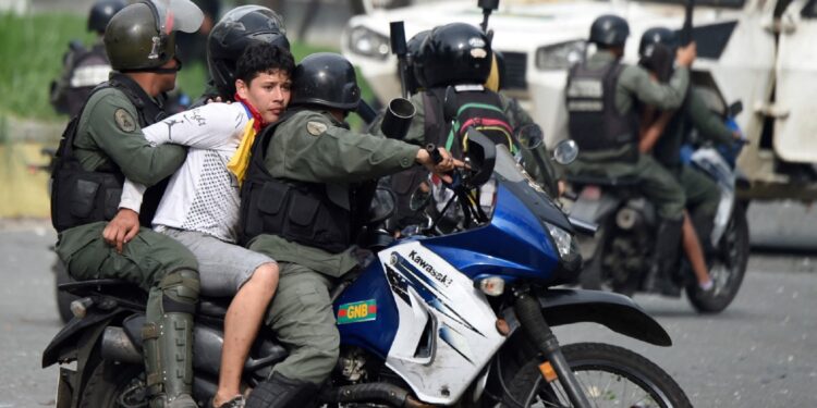 An anti-government activist is arrested by the National Guard during clashes in Caracas on July 27, 2017 on the second day of a 48-hour general strike called by the opposition. Venezuela's opposition called for a nationwide protest on Friday in outright defiance of a new government ban on demonstrations ahead of a controversial weekend election. (Photo by JUAN BARRETO / AFP)