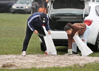 Ciudadanos en la Florida ponen bolsas de arena para apaciguar lluvias ante la amenaza del huracán Milton. | Foto: AFP