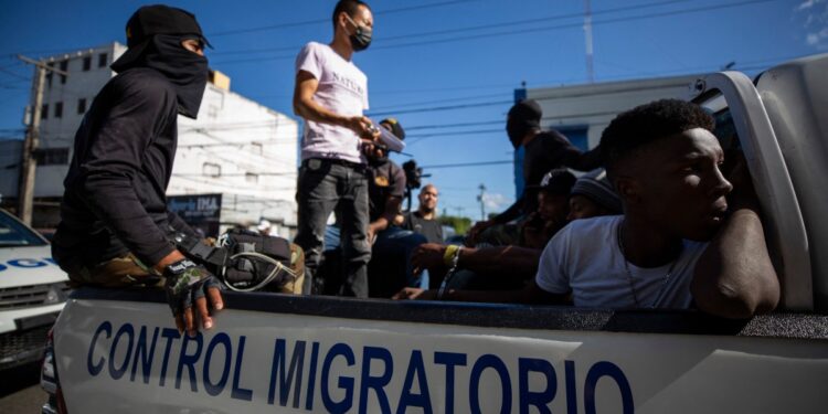 (FILES) People are detained by agents of the Dominican General Directorate of Migration in Santo Domingo on December 1, 2021. - The Dominican Republic unveiled a plan on October 2, 2024, to start deporting 10,000 undocumented Haitians a week as part of a crackdown on migration from its troubled neighbor on the island of Hispaniola. (Photo by Erika SANTELICES / AFP)