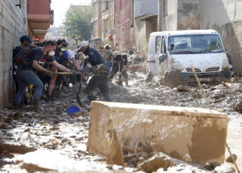 MASSANASSA (VALENCIA), 06/11/2024.- Un grupo de voluntarios saca lodo de una de las calles de Massanassa (Valencia), este miércoles. Voluntarios, fuerzas de seguridad, bomberos, militares y vecinos de las localidades más afectadas por la dana continúan con las tareas de limpieza mientras los equipos de rescate siguen rastreando la zona para intentar localizar a las personas que aún sigue desaparecidas. EFE/Miguel Ángel Polo