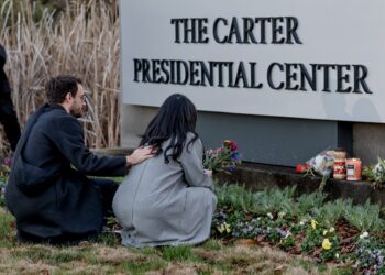 Atlanta (United States), 29/12/2024.- Mourners Nick Holte (L) and Esther Hyejin Chung (R) leave flowers in reaction to the death of former US President Jimmy Carter at the Carter Presidential Center Atlanta, Georgia, USA, 29 December 2024. Carter died on 29 December 2024 at his home in Plains, Georgia, The Carter Center confirmed. Carter was the 39th US President and a winner of the Nobel Peace Prize. He was also the longest-lived president in US history. EFE/EPA/ERIK S. LESSER