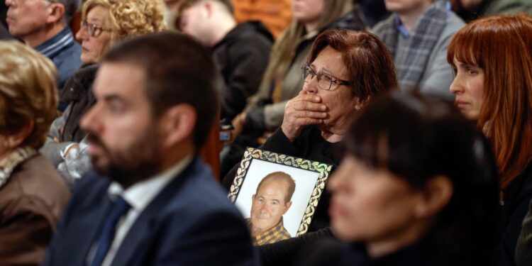 A woman holds the photograph of a victim during a funeral mass held on December 9, 2024 at the Cathedral of Valencia in memory of the victims of the deadly floods that devastaded the region in late October. - According to authorities, 230 people died during the floods on October 29, 222 of them in the Valencian region, while four others are still missing. (Photo by Kai FOSTERLING / POOL / AFP)