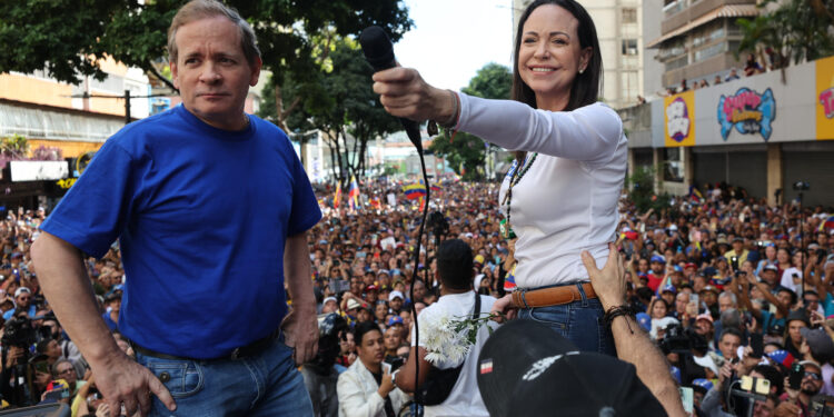 AME9799. CARACAS (VENEZUELA), 09/01/2025.- La líder antichavista María Corina Machado (d) saluda a sus seguidores junto al exdiputado venezolano Juan Pablo Guanipa este jueves, en una manifestación en Caracas (Venezuela). Machado anunció, a un día de la toma de posesión presidencial, el comienzo de una "nueva fase" del proceso para "la libertad de Venezuela", y pidió a los ciudadanos estar atentos a las señales sobre los próximos pasos. EFE/ Miguel Gutiérrez