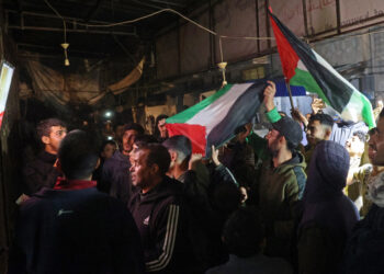 People celebrate along a street at Deir el-Balah in the central Gaza Strip, on January 15, 2025, amid the ongoing war in the Palestinian territory between Israel and Hamas. Crowds of Gazans chanted and embraced on January 15 as news spread that a ceasefire and hostage release deal had been reached between Israel and Hamas aimed at ending more than 15 months of war in the Palestinian territory. (Photo by Eyad BABA / AFP)