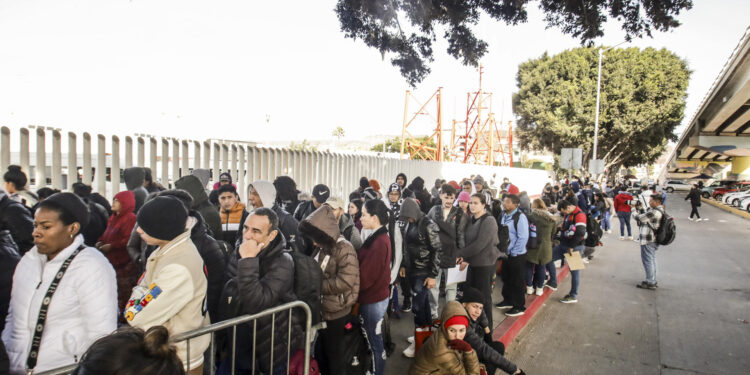 MEX333. TIJUANA (MÉXICO), 20/01/2025.- Migrantes permanecen varados este lunes, en el puerto fronterizo de El Chaparral, en Tijuana (México). Cientos de migrantes quedaron varados después de que el gobierno del nuevo presidente, Donald Trump, cancelara el programa CBP-One, que permitía a migrantes solicitar citas para pedir asilo en EE.UU. a través de los puertos de entrada en la frontera con México. EFE/ Joebeth Terríquez