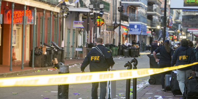 FBI investigators arrive at the scene where the white Ford F-150 pickup truck that crashed into a work lift after allegedly driving into a crowd of New Year's revelers in the French Quarter of New Orleans, Louisiana, on January 1, 2025. - At least 10 people were killed and 30 injured Wednesday when a vehicle plowed overnight into a New year's crowd in the heart of the thriving New Orleans tourist district, authorities in the southern US city said. (Photo by Matthew HINTON / AFP)