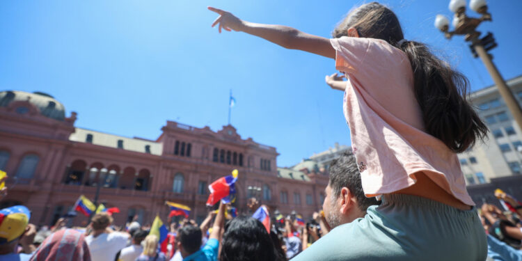 AME8502. BUENOS AIRES (ARGENTINA), 04/01/2025.- Seguidores del líder opositor venezolano Edmundo González Urrutia reaccionan durante la visita de González Urrutia a la Casa Rosada este sábado, en Buenos Aires (Argentina). El presidente de Argentina Javier Milei y González Urrutia salieron al balcón de la Casa Rosada para saludar a los miles de venezolanos congregados en la Plaza de Mayo de Buenos Aires, que acompañaron al líder opositor venezolano en su primera parada de una gira por varios países latinoamericanos. EFE/ Juan Ignacio Roncoroni