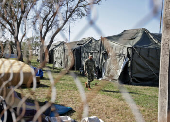 A member of the Mexican Navy walks past a row of tents as they begin building a temporary shelter on the border in Matamoros, Tamaulipas state, Mexico on January 22, 2025, ahead of US President Donald Trumps promised deportations. (Photo by QUETZALLI BLANCO / AFP)