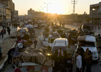 NUSEIRAT (GAZA), 25/01/2025.-Cientos de gazatíes, muchos de ellos cargando en brazos la misma lona y cuerdas que han usado como refugio en el sur de Gaza durante la guerra con Israel, aguardan en Nuseirat (centro) el momento que el Ejército israelí les deje atravesar el Corredor Netzarim y regresar al norte de la Franja.EFE/Stringer