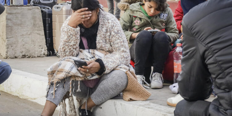 MEX333. TIJUANA (MÉXICO), 20/01/2025.- Migrantes permanecen varados este lunes, en el puerto fronterizo de El Chaparral, en Tijuana (México). Cientos de migrantes quedaron varados después de que el gobierno del nuevo presidente, Donald Trump, cancelara el programa CBP-One, que permitía a migrantes solicitar citas para pedir asilo en EE.UU. a través de los puertos de entrada en la frontera con México. EFE/ Joebeth Terríquez