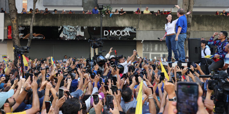 AME9799. CARACAS (VENEZUELA), 09/01/2025.- La líder antichavista María Corina Machado (i) saluda al exdiputado venezolano Juan Pablo Guanipa este jueves, en una manifestación en Caracas (Venezuela). Machado anunció, a un día de la toma de posesión presidencial, el comienzo de una "nueva fase" del proceso para "la libertad de Venezuela", y pidió a los ciudadanos estar atentos a las señales sobre los próximos pasos. EFE/ Miguel Gutiérrez