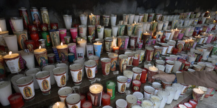 Candles left by faithfuls are pictured after a mass for the health of Pope Francis at the Basilica de Guadalupe in Mexico City on February 23, 2025. Pope Francis's condition "remains critical", the Vatican said Sunday on his 10th day in hospital as Catholics around the world prayed for the 88-year-old's recovery. (Photo by Alfredo ESTRELLA / AFP)