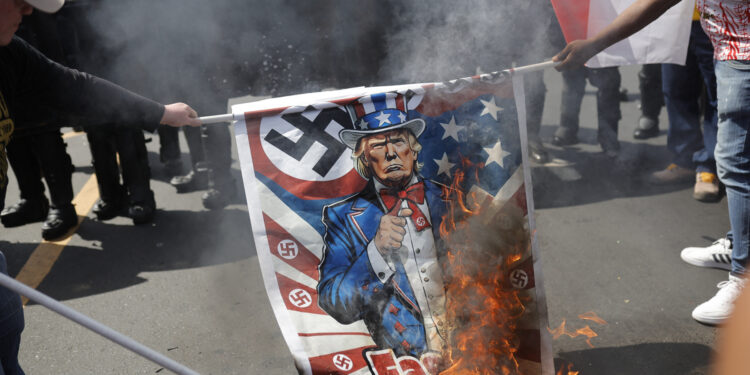 AME6163. CIUDAD DE PANAMÁ (PANAMÁ), 02/02/2025.- Personas queman un cartel con la imagen del presidente de Estados Unidos, Donald Trump, durante una protesta por la visita del Secretario de Estado de Estados Unidos, Marco Rubio, este domingo en Ciudad de Panamá (Panamá). El presidente panameño, José Raúl Mulino, y Rubio se reúnen en plena disputa por el Canal de Panamá, que el mandatario estadounidense ha amenazado con "recuperar". EFE/ Bienvenido Velasco